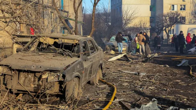 A damaged car at the site of Russian shelling near a residential building in Kharkiv