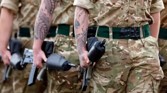 A file photo showing British soldiers in camouflage carrying guns, only their torsos and legs are visible and their faces are not in the image