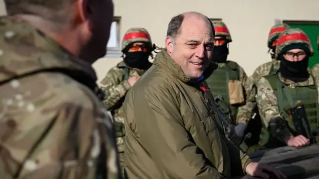 Defence Secretary Ben Wallace speaks with personnel after observing Ukrainian troops undergoing training at a military facility