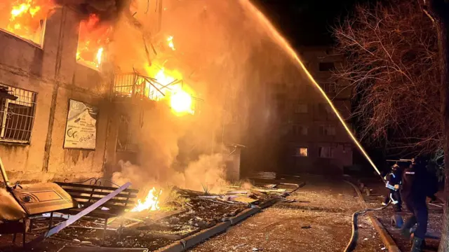 Firefighters work at the site of a residential area hit by a Russian military strike, amid Russia's attack on Ukraine, in the town of Dobropillia