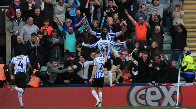 Djeidi Gassama leaps in celebration in front of the jubilant travelling Sheffield Wednesday fans