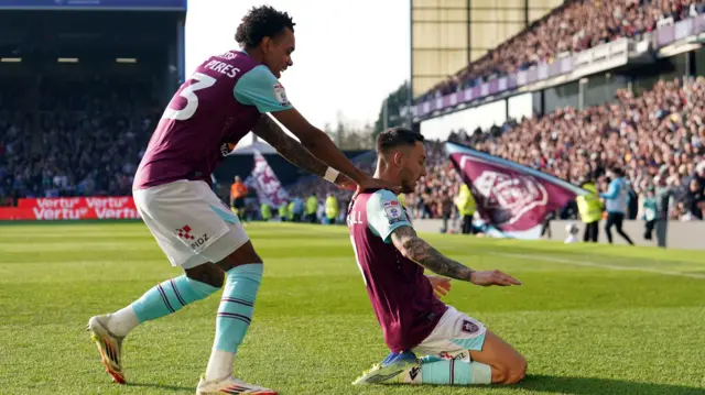 Josh Brownhill slides on his knees after scoring Burnley's third against Luton