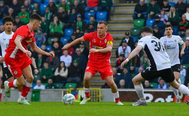 Rory Hale of Cliftonville gets away from Jordan Jenkins of Glentoran