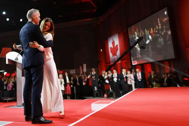 Mark Carney hugs his daughter on stage