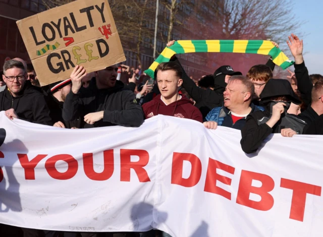 Manchester United fans with a banner in protest