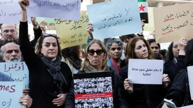 Protestors holding placards written in Arabic