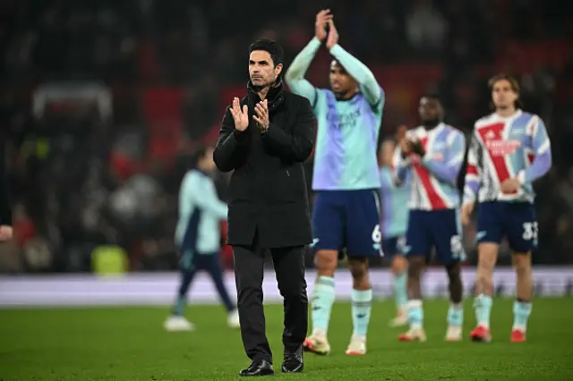 Mikel Arteta (C) applauds fans on the pitch