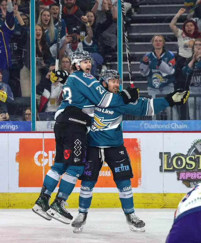 Mike Lee leaps into the arms of Scott Conway after scoring