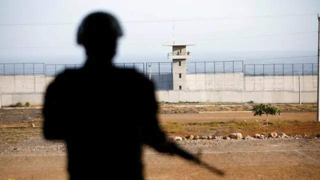 This picture taken on a media tour of the Cecot prison shows a soldier standing guard outside