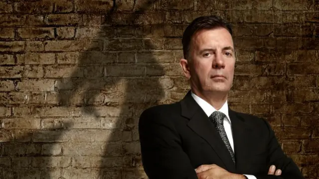 Former Dragon's Den star Duncan Bannaytne looks serious as he stares down the barrel of the camera.