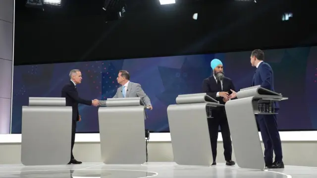 Liberal leader Mark Carney shakes hands with Bloc Quebecois leader Yves-Francois Blanchet, while New Democratic Party leader Jagmeet Singh shakes hands with Conservative ;eader Pierre Poilievre on stage after Wednesday's debate.