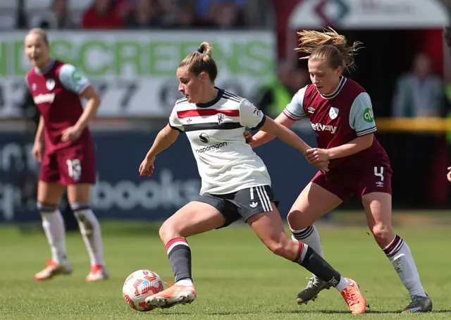 Ella Toone holds off a tackle from behind
