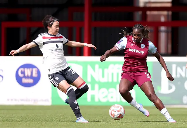 Asseyi and Miyazawa duel for the ball in midfield