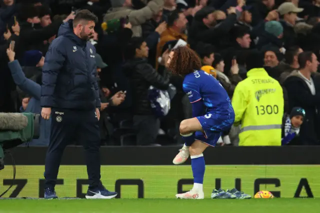 Marc Cucurella of Chelsea changes his boots on the touchline