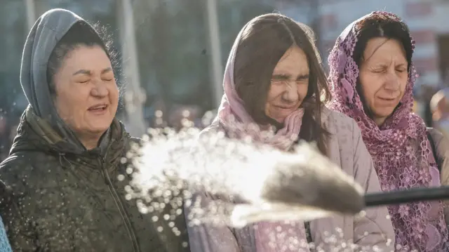 Believers attend a ceremony of blessing Easter cakes and traditional food baskets after the Easter service, amid Russia's attack on Ukraine, in front of the St. Andrews Church in the town of Bucha