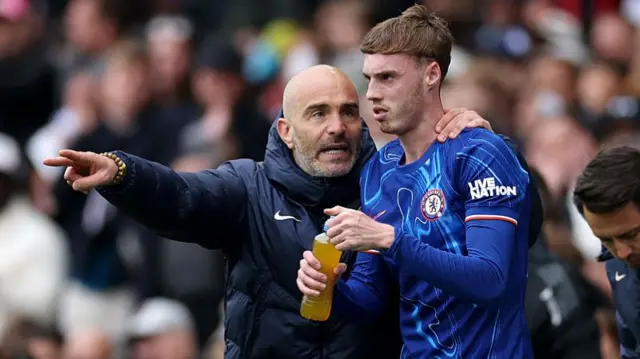 Enzo Maresca, Manager of Chelsea, talks to Cole Palmer