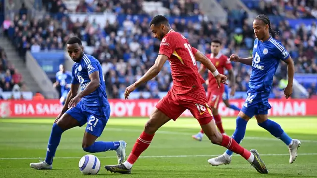 Cody Gakpo of Liverpool runs with the ball under pressure from Ricardo Pereira and Bobby Decordova-Reid
