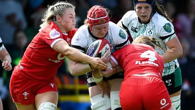 Aoife Wafer tackled by two Welsh players