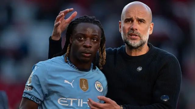 Jeremy Doku of Manchester City interacts with Pep Guardiola