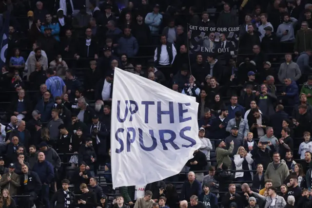 Fan waves a flag reading up the spurs