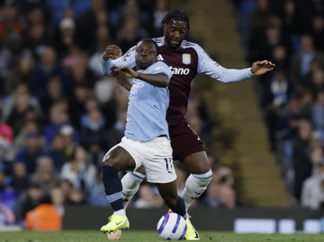 Aston Villa's Axel Disasi in action with Manchester City's Jeremy Doku