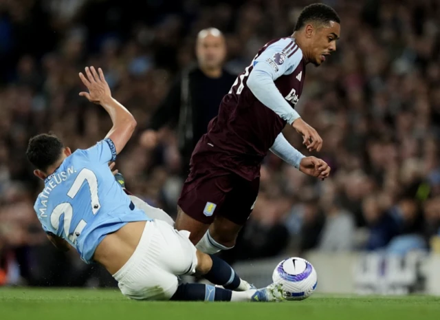 Manchester City's Matheus Nunes (left) and Aston Villa's Jacob Ramsey (right) battle for the ball