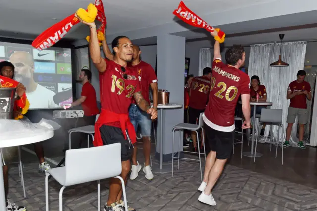 Virgil van Dijk and Andy Robertson swinging Liverpool scarves after winning the Premier League title