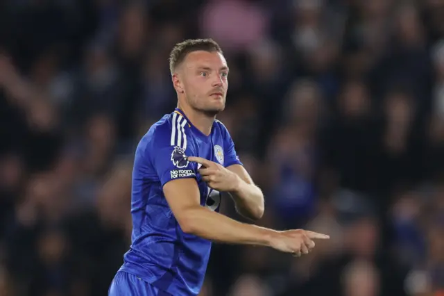 Jamie Vardy pointing to the Premier League patch on his shirt