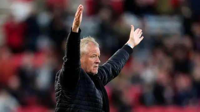 Chris Wilder holds his arms in the arm on the touchline