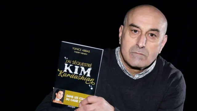 Abbas holding a book with Kim Kardashian on it