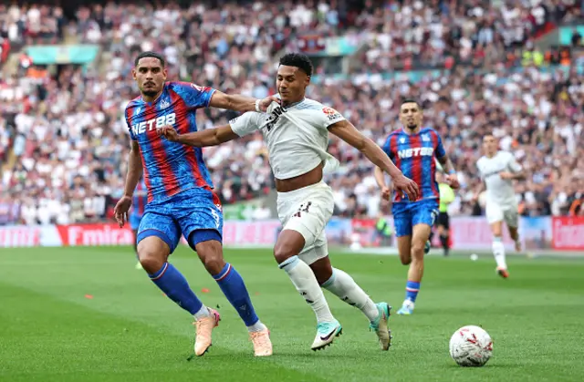 Ollie Watkins of Aston Villa is challenged by Maxence Lacroix