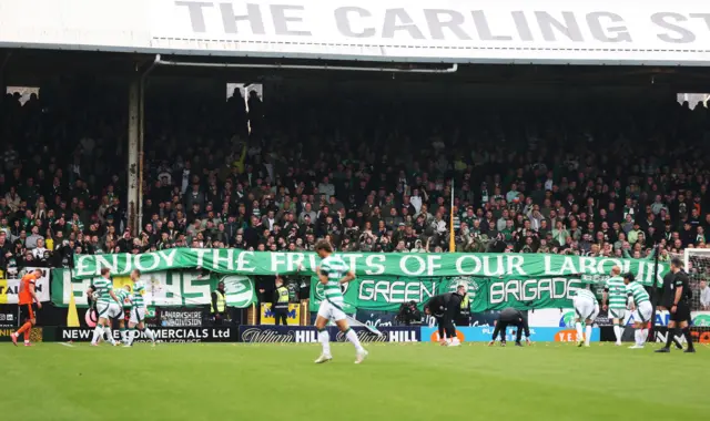 Celtic fans unveil a banner after they lobbed tangerines onto the pitch