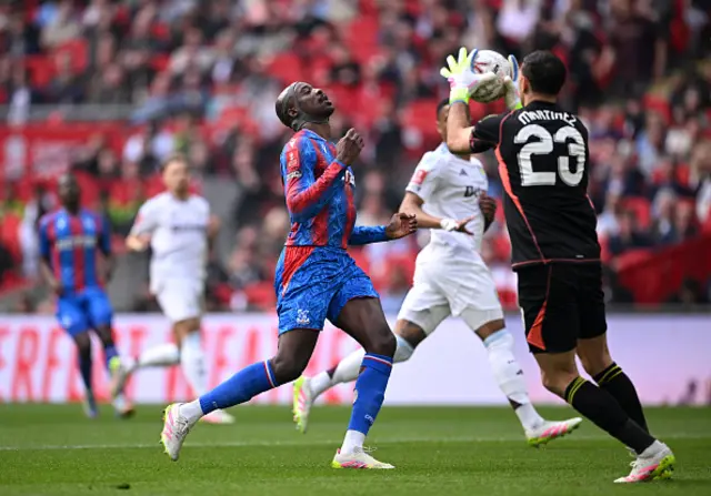 Emiliano Martinez of Aston Villa makes a save ahead of Jean-Philippe Mateta