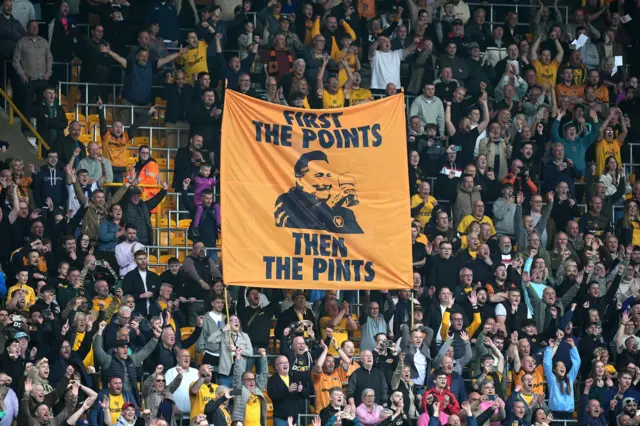 "first the points then the pints" banner with Pereira face on in the stands