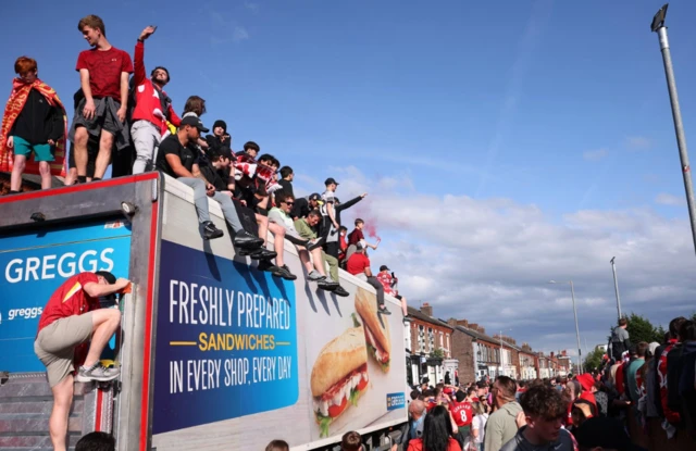 Liverpool fans on top of a truck outside the stadium
