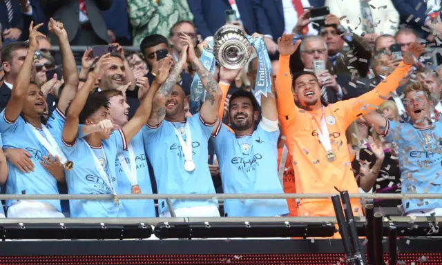 Manchester City players hold up the FA Cup