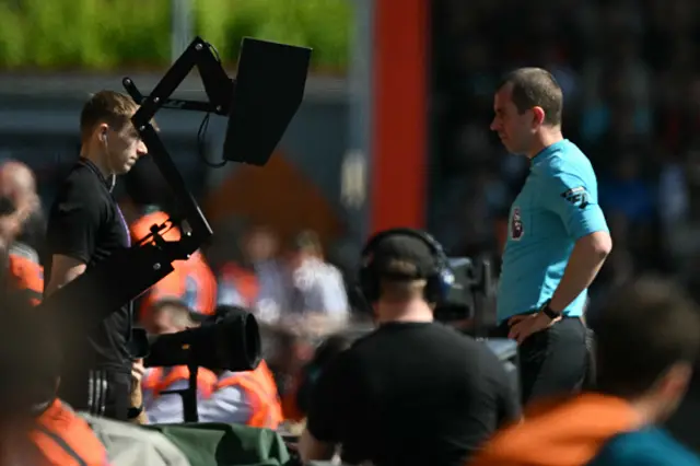 Referee Peter Bankes checks the VAR screen