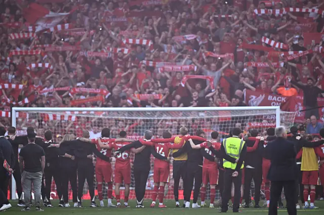 Liverpool players celebrate with their fans on the pitch