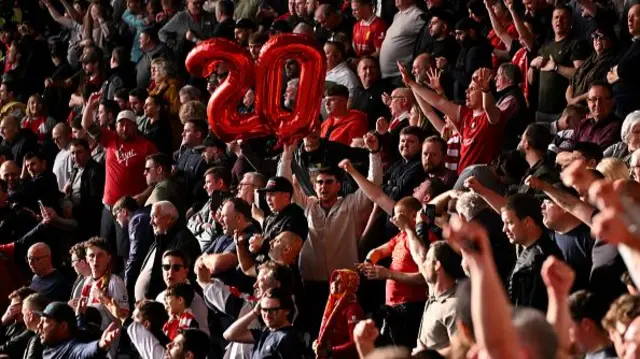 Fans of Liverpool hold up balloons