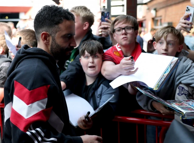 Manchester United manager Ruben Amorim with fans outside the stadium