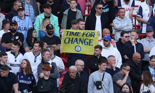 Tottenham Hotspur fan holds up a sign reading Time for change