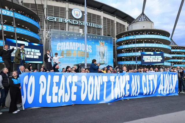 Manchester City fans hold up a banner at a protest outside the Etihad Stadium