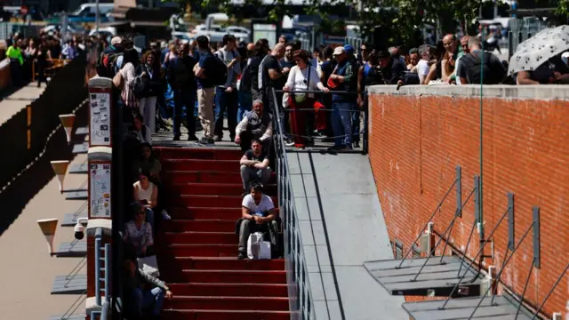 People gather around a stairwell at a train station during a power outage in Madrid, Spain, April 28, 2025