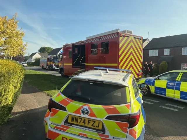 Police cars and fire engines on a road in Yate, Bristol