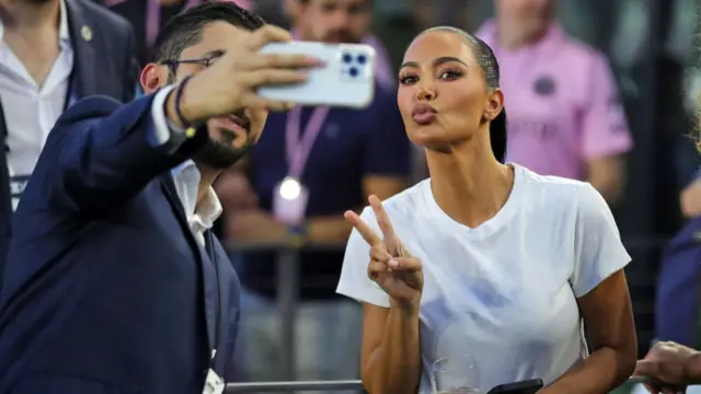 Kim pouts for a selfie at a basketball game