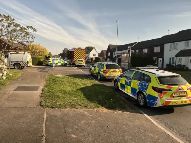 Police cars and fire engines on a road in Yate, Bristol