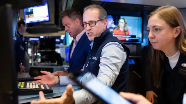 Traders on the New York Stock Exchange earlier