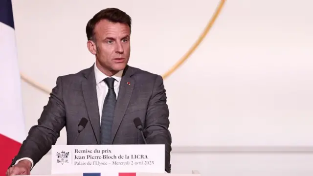 French President Emmanuel Macron, standing behind a podium.
