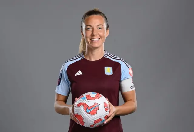 Rachel Corsie smiles and holds a WSL match ball