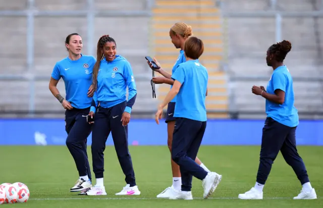 Chelsea players look at a phone and chat